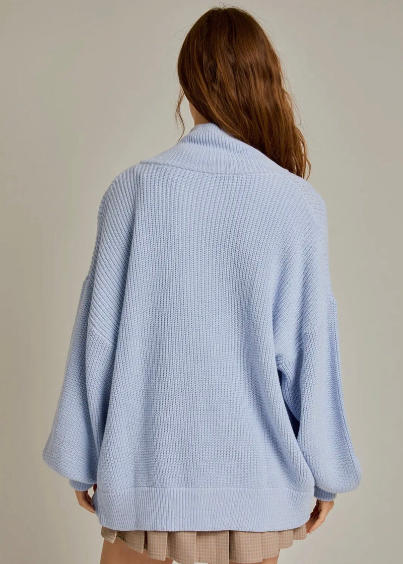 Light blue ribbed sweater worn by a person on a neutral background