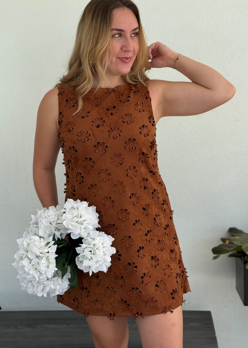 boutique owner wearing mini soft brown dress with floral cutouts
