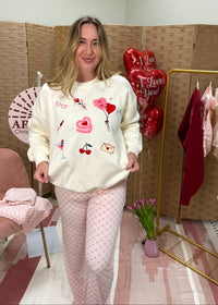 Woman in a room with a pink chair, clothes rack, and heart-shaped balloons.