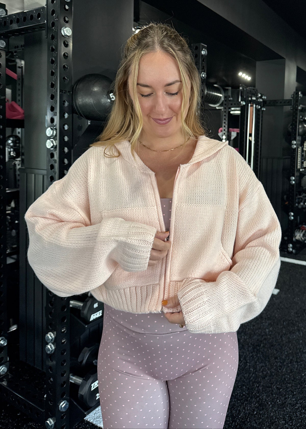 Person wearing a light pink sweater and polka dot pants 